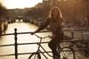 Long-haired woman on bike on a bridge